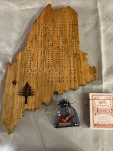 Wood carved Cribbage Board with old state of Maine flag emblem burned onto it, pegs, and deck of cards